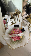 Bouquet of pink roses with a 'Happy Graduation' in a decorative package.